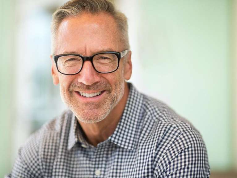 man in glasses smiling | dental bridges oakbrook terrace