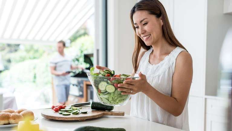 woman making a salad | dental exams oakbrook terrace il