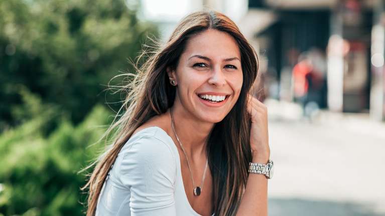 woman in white shirt smiling | dentist oakbrook terrace