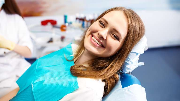 woman sitting in dental exam chair | dentist oakbrook terrace il