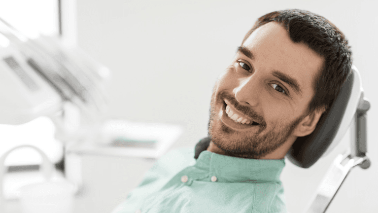 man sitting in dentist exam chair | dentist oakbrook terrace