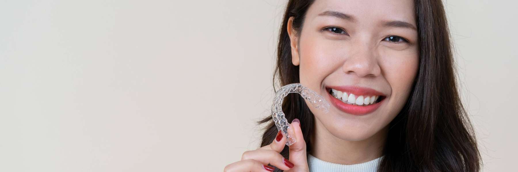 Woman holding her invisalign in oakbook