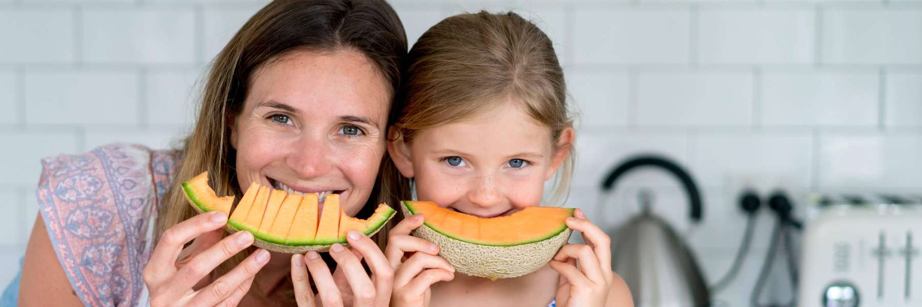 woman and daughter smiling with fruit | dentist near me